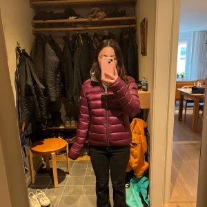 Vinröd dunjacka från Colmar - Säljer en snygg vinröd dunjacka från Colmar. Den är ansvänd fåtal gånger och är som ny. Den kostar 3700kr i nypris.