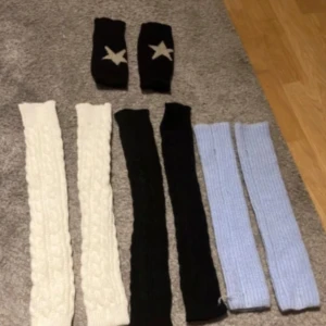 Svarta stickade handledsvärmare med stjärna - Snygga svarta stickade handledsvärmare med en vit stjärna på ovansidan. Perfekta för att hålla händerna varma samtidigt som fingrarna är fria. Passar bra till både vardag och lite mer avslappnade tillfällen.