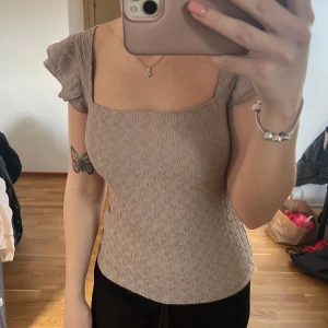 Beige topp med volangärmar - Säljer en snygg beige topp som använd fåtal gånger 