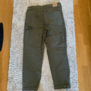 Gröna byxor från Les Deux - Breda gröna byxor från Les Deux. Byxorna har en vid passform med praktiska fickor och knappar. Använt enstaka gånger. 