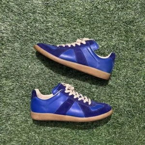 Blå Maison Margiela  sneakers - Maison Margiela  sneakers i blått skinn och mocka med beige snörning och klassisk gummisula. Snygg retrostil med rund tå och lågt skaft. Tillverkade i Italien och har en stilren, sportig vibe som sticker ut.