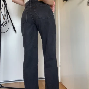 Svarta raka jeans från H&M - Säljer ett par svarta H&M jeans med hög midja och raka ben. Jeansen har klassiska bakfickor och är tillverkade i kraftigt denimtyg. Perfekta för dig som gillar en clean och tidlös look.