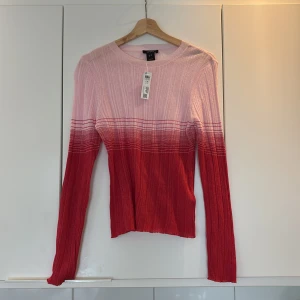 Ribbad rosa och röd långärmad tröja - Säljer en ribbad långärmad tröja från Gina Tricot i snygg ombre från ljusrosa upptill till röd nedtill. 