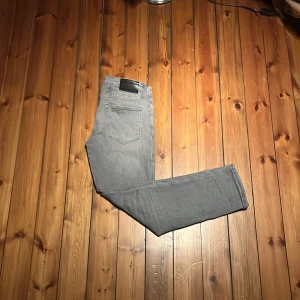 Grå jack&jones jeans Regular Clark - Snygga grå jeans i modellen Regular Clark med klassisk femficksdesign. Jeansen har rak passform och är tillverkade i mjukt denimtyg. Perfekta för dig som gillar en stilren look. Storlek W28 L32 kom med frågor och pruta för snabb affär 