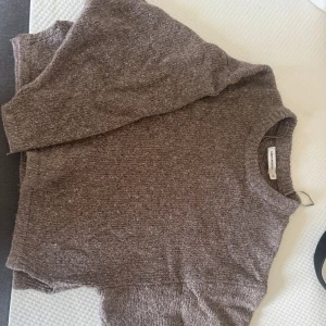 Brun stickad tröja Carin Wester - Mysig brun stickad tröja från Carin Wester i storlek M. Tröjan har en avslappnad passform, rund halsringning och långa ärmar.