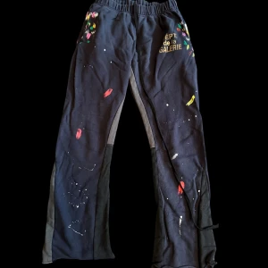 Gallery Dept Mjukisbyxor - Unika svarta mjukisbyxor från Gallery Dept. i bomull med färgstänk och tryck på framsidan. Byxorna har elastisk midja med snörning och raka ben med coola färgdetaljer. Perfekta för dig som gillar streetwear med konstnärlig vibe.