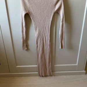 Beige ribbad långklänning Bik Bok - Supersnygg beige ribbad långklänning från Bik Bok. Klänningen har lång ärm, figurnära passform och är tillverkad i ett mjukt, stretchigt material. 