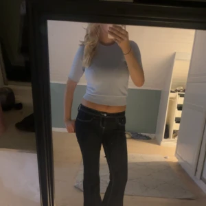 Ljusblå croppad stickad tröja med spets - Supersöt ljusblå croppad stickad tröja med korta ärmar och spetsdetalj i ärmslutet. Perfekt för dig som gillar en feminin och trendig stil. Sitter tajt och är riktigt mjuk mot huden.