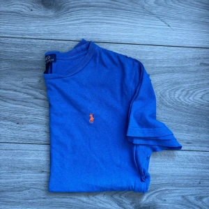 Ljusblå Ralph Lauren T-shirt, stl S, ny utan prislapp - Skicka gärna vad du tycker att t-shirten är värd, jag är öppen för bud, skicka gärna ett! Ljusblå T-shirt från Ralph Lauren i storlek S, ny utan prislapp. Klassisk modell i mjuk bomull med den ikoniska broderade loggan på bröstet. En tidlös basic med premiumkänsla, perfekt både till vardag och avslappnat snygga outfits. Nypris ca 600 kr, så passa på att fynda till ett bättre pris, 249 kr! Kika gärna in min profil, jag lägger upp fler liknande plagg löpande! Ralph Lauren t-shirt ljusblå blå herr 