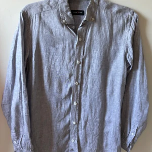Grå linneskjorta från Tailor Store - Grå Linneskjorta som passar storlek S och M. Aldrig använd