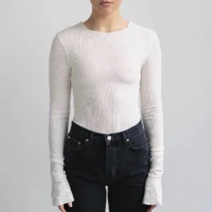 Vit långärmad topp från A-DSGN - Vit långärmad topp från A-DSGN i ribbad bomullsmix. Modellen är tight och har en enkel, stilren design med rund halsringning och extra långa ärmar. Perfekt att styla med jeans eller kjol för en clean look.