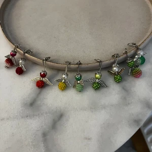 Färgglada ängelberlocker i pärlor - Lycoänglar säljses. perfekt att hänga på jackan eller varför inte på något halsband eller koppel till ett djur. Bra skick.  helt nya och handgjorda av mig. 25kr st 2 för 40kr 3 st för 60kr 4 st för 80kr och 5st för 100kr 