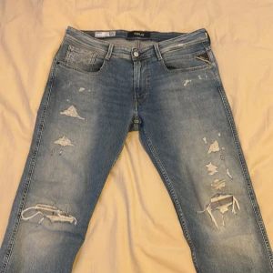 Replay jeans - Snygga ljusblå jeans från Replay, modell Anbass. De är slim fit o har snygga slitningar för en trendig look. Perfekta för en avslappnad stil. Hör av er vid frågor o funderingar!
