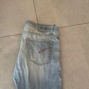 Ljusblå Dondup jeans, storlek 48 - Snygga ljusblå jeans från Dondup med klassisk femficksdesign och orangea sömmar. Tillverkade i Italien, storlek 48. Jeansen har en rak passform och sitter slim pris går att diskuteras!