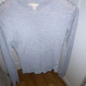 Grå tunn tröja  - Tröjan är  lite genomskinlig alltså att man ser igenom.