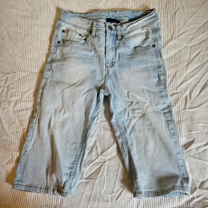 Långa skinny shorts - Långa ljusblå shorts i skinny jean-modell, skulle säga mid-high waist (under naveln) i höjd. 