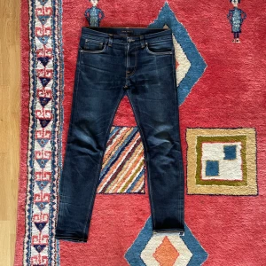 Nudie Jeans Lean Dean Selvedge - Säljer dessa Selvedge nudie jeans i modellen Lean Dean, Slimmare passform. Jeansen är använda men och har små slitage. Ett vid grenen, samt lite vid fotändan, men bara att höra av dig om man vill ha bild på allt. Måtten är: Bredd, ca 45cm. Längd ca 105cm. Benöppning, ca 16cm. DISKUTERBART PRIS!