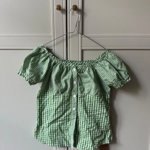 Grön- och vit rutig offshoulder blus - Superfin grön- och vit rutig blus. Den är i storlek 152, vilket passar en xs eller xxs💚