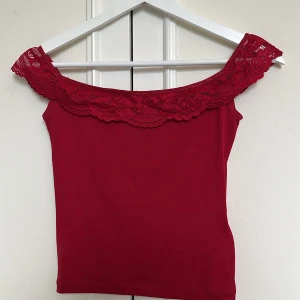 Röd offshoulder topp  - Röd offshoulder topp från Motel Rocks med spetskant runt axlarna. Stretchigt material, använd 1 gång!