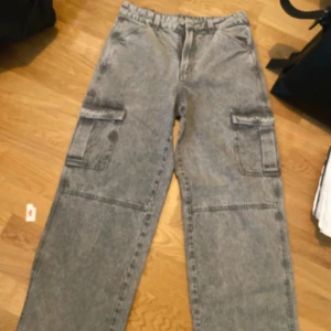 Grå cargopants  - Säljer ett par grå cargopants med stora fickor på sidorna. Helt nya från H&M