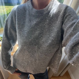 Grå stickad tröja med paljetter - Supermysig grå stickad tröja med glittriga paljetter! Jättefin o mysig tröja till hösten!