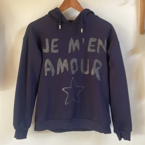 Mörkblå hoodie med glittertext från Gina Tricot - Jag säljer denna mörkblå hoodie från Gina Young. Den är i storlek 146/152 och i fint skick💙
