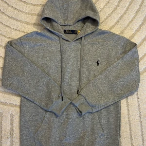 Ralph Lauren Hoodie - 👕 Grå hoodie från Polo Ralph Lauren – helt ny och aldrig använd! Storleken är tyvärr för liten för mig, därför säljer jag den vidare. Klassisk modell med ficka framtill och den ikoniska Polo-loggan på bröstet.  💸 Pris: 499 kr 🔥 Pris går att diskutera privat! 