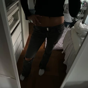 Grå slitna jeans med hål på knäna - Säljer ett par grå jeans med låg midja. Jeansen har snygga slitningar. Storlek 164. Midjemått 37cm tvärs över. Innerbenslängden: ca78cm och väldigt stretchiga