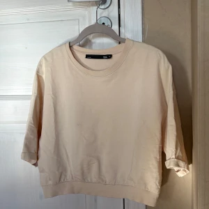 Beige T-shirt  - Säljer en beige T-shirt från 157 med rund hals och ribbad kant nedtill. Tröjan har långa ärmar. Perfekt för chill dagar och enkel att matcha med jeans eller mjukisbyxor.