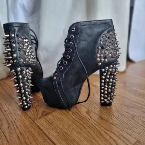 Jeffrey Campell ☆ strl 38 - Riktigt coola svarta boots med snörning, hög klack och platåsula. Skorna är täckta med silvriga nitar och spikes på hälen och klacken för en edgy look. Tillverkade i skinnliknande material och har rund tå.