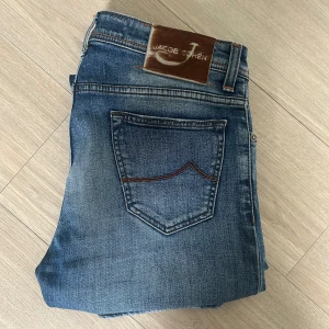 Jacob Cohen jeans  - Säljer snygga Jacob Cohen jeans, modell 688.C i storlek 32. Jeansen är i mycket fint skick med endast minimalt slitage vid benslut och framfickor. Klassisk ljus tvätt, skön stretch och exklusiva detaljer – italiensk kvalitet rakt igenom. Nypris ca 5500 kr. Supersnygga och bekväma – ett riktigt kap! Hör av dig vid frågor eller funderingar🤔