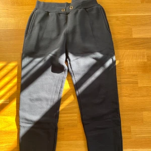 Mörkblå mjukisbyxor - Mörkblå mjukisbyxor med resår i midjan. Saknar snöret runt midjan. Byxorna har två sidofickor. Perfekta för chill dagar eller när du vill vara bekväm. Klassisk och enkel design som funkar till det mesta. Kan mötas upp i Trollhättan eller Alingsås. Kan skickas men då tillkommer en fraktkostnad.