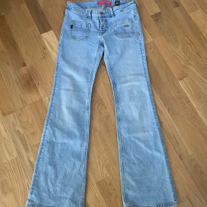 Ljusblåa jeans  - Supersnygga lågmidjade bootcut jeans i färgen blå! Vintage och går inte att få tag på längre! Storlek 26 , midja: 36 cm, midjehöjd: 20 cm, innerben: 82 cm