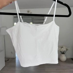 Vit croppad linnetopp - Säljer en enkel och fräsch vit croppad linnetopp med smala, justerbara axelband. Toppen är i mjuk bomullsmix med lite stretch för extra komfort. Perfekt till jeans eller kjol <3 Önskar du veta exakta mått? Tveka inte att höra av dig!