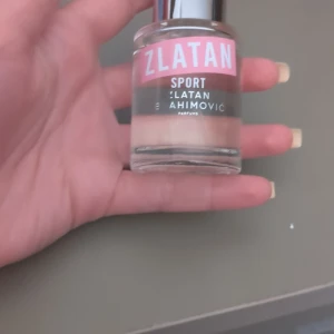 Zlatan Sport parfym - Fräsch parfym från Zlatan Ibrahimović Parfums i modellen Sport. Flaskan är rund och genomskinlig med silverfärgad kork och rosa etikett. Doften är sportig och energisk, perfekt för dig som gillar en aktiv livsstil. (Använt typ 1 gång☺️)