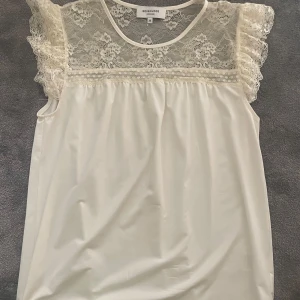 Spets blus  - Krämvit blus med spets och volanger vid ärmarna. Från Rosemunde i storlek 36. Nypris runt 700kr.