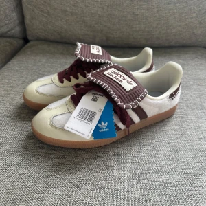 Adidas Samba Wales Bonner vinröd/vit - Otroligt feta och unika Adidas Samba Wales Bonner sneakers i vitt och vinrött. Skorna är i storlek 38 men sitter som 37 och är helt oanvända. Säljer för det var för små för mig. Kommer med Wales Bonner dustbag. Boxen har jag tyvärr slängt. Perfekt för dig som vill sticka ut. Skriv vid frågor eller funderingar! 