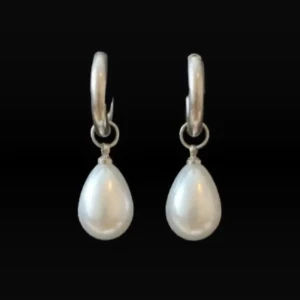 Silverörhängen med droppformade pärlor - Stilrena örhängen i silver med droppformade vita pärlor som hänger från små ringar. Perfekta för dig som gillar klassiska smycken med en elegant touch. Passar till alla tillfällen när du vill känna dig extra fin.