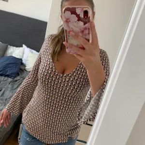 Mönstrad blus från Gina Tricot XS - Supersnygg blus från Gina Tricot i storlek XS. Blusen har ett grafiskt mönster i svart, vitt och ljusrosa, v-ringad hals och vida, långa ärmar. Tunt och mjukt material som känns skönt mot huden. Ej använd!💕