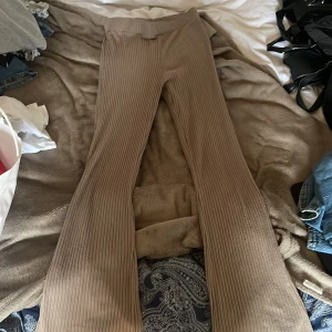Ribbade bruna byxor från H&M XS - Säljer ett par ribbade bruna byxor från H&M i storlek XS. Byxorna har en skön stretchig passform, hög midja och utsvängda ben. Perfekta för en chill och trendig look, superlätta att matcha med både sneakers och boots.
