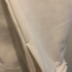 Vita mjukisbyxor från SMOG, storlek M - Säljer ett par vita mjukisbyxor från SMOG i storlek M. Byxorna har resår och snörning i midjan samt ribbade muddar vid bensluten. Tillverkade i mjukt bomullsmaterial för maximal komfort. Perfekta för chill dagar eller när du vill vara extra bekväm.