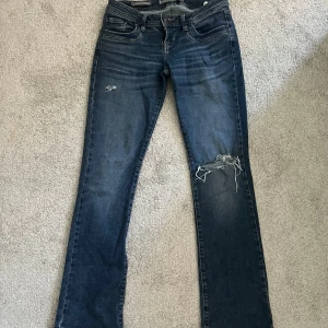 Mörkblå jeans från LTB - Mörkblå jeans från LTB med hål på ena benet. Bootcut ben och normal passform💕