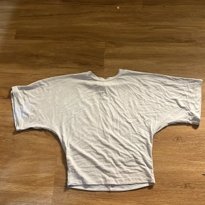 Ijus blå  loose-fit t-shirt med breda ärmar - Enkel och stilren ljus blå t-shirt med loose-fit passform och breda, korta ärmar. T-shirten har rund halsringning och är tillverkad i mjuk bomull, perfekt för en avslappnad look. Passar dig som gillar oversized vibe och minimalistisk stil. Den e lite tajt vid midjan och flumsig vid armarna 