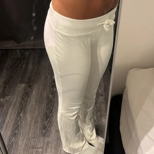 Nelly Vita mjukisbyxor - Säljer ett par vita mjukisbyxor från nelly med bred resår i midjan och snörning framtill. Byxorna har en rak passform med lite utsvängda ben och är tillverkade i mjukt bomullsmaterial. Perfekta för en chill och avslappnad look.