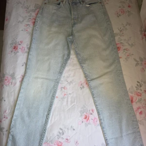 Ljusblå mom jeans från &Denim - Säljer ett par ljusblå mom jeans från &Denim i klassisk femficksmodell. Jeansen har ultrahög midja och raka ben, tillverkade i bomullsdenim. Perfekta för dig som gillar en avslappnad och trendig look.