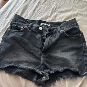 Svarta jeansshorts Junkyard XS - Snygga svarta jeansshorts från Junkyard i modell Kay Rah. Perfekta för en chill sommarlook och passar till allt. Dragkedja och knapp framtill. Stl XS.