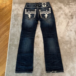 Rock Revival Jeans - Säljer dessa bootcut rocks då de inte längre kommer till någon användning.  Förutom heelbiten som är synligt på bilderna, så är dem i mycket gott skick.  Hör av er vid ytterligare frågor.