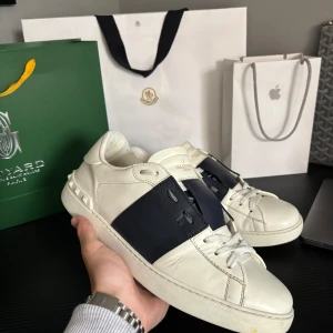 Valentino Open Navy  - Valentino Garavani Sneakers – Navy Blue Stripe 	•	Äkta Valentino Garavani sneakers 	•	Marinblå stripe – klassisk och stilren look 	•	Mycket bra skick, inga defekter 	•	Storlek 43 – passar även 43–44 	•	Condition – 9/10  🚚 FAST SHIPPING ON ALL ORDERS 🧼 📦 No returns 📦 ✅ All products are 100% authentic 🌟 100+ 5 Star Reviews  Tags ↓ #y2k #y2kstyle #y2kfashion #y2kaesthetic #y2ktrend #opium #opiumpunk #opiumstyle #opiumhoodie #opiumlovers #opiumgang #cargo #casual #oldschool #oldmoney #travisscott 