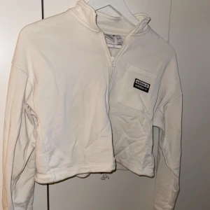 Vit adidas kofta - Vit croppad adidas kofta, bra skick men har fått en fläck (osäker om går bort i tvätt)