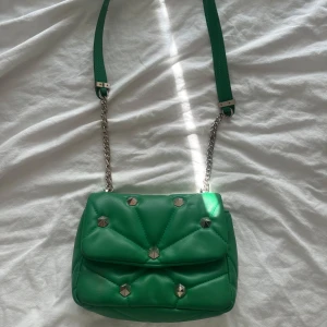 Grön axelväska med nitar - Snygg grön axelväska med silverfärgade nitar och kedjerem. Perfekt storlek och passform🌟